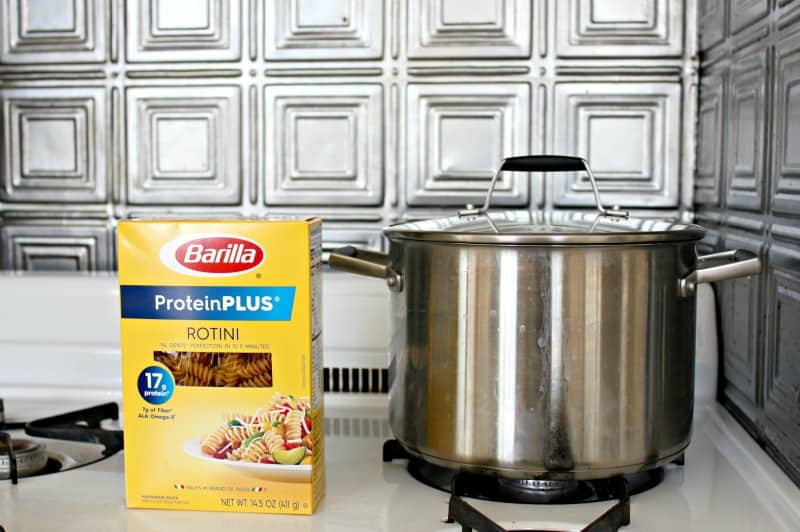 a box of pasta on the stove near a pot