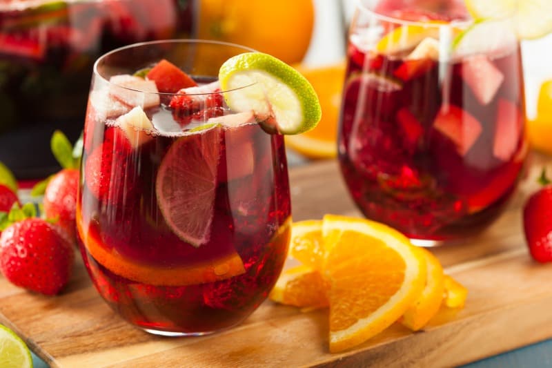two sangria mocktails with limes on a wooden board