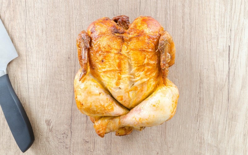 a rotisserie chicken on a cutting board