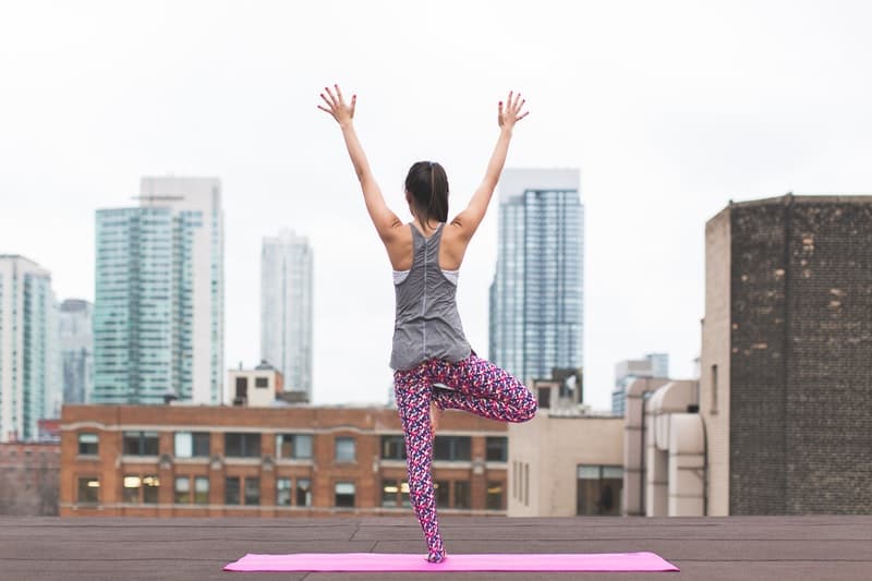 a woman doing yoga on a rooftop