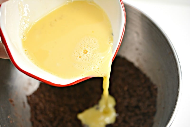 pouring butter into cake mix