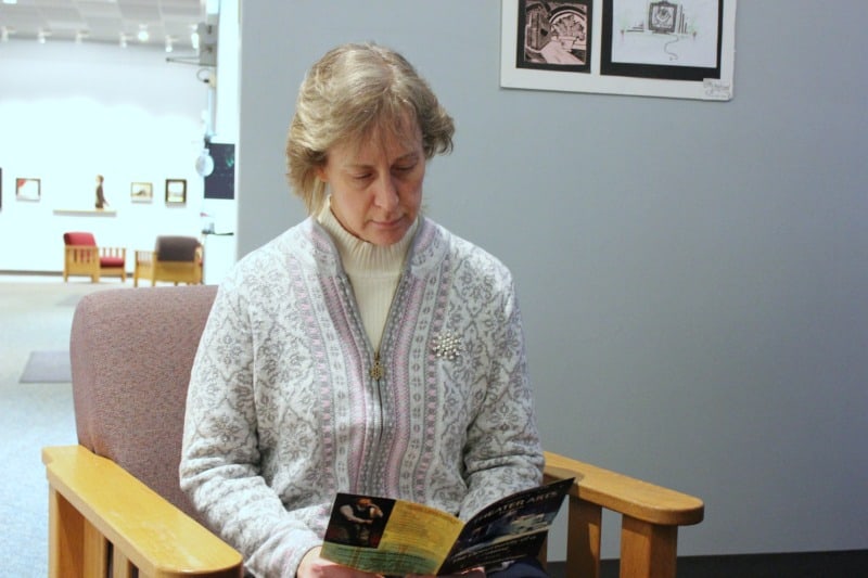 woman reading an art gallery brochure