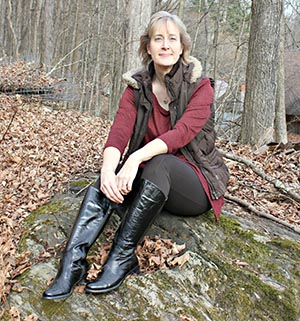 the blog author sitting in the woods on a rock