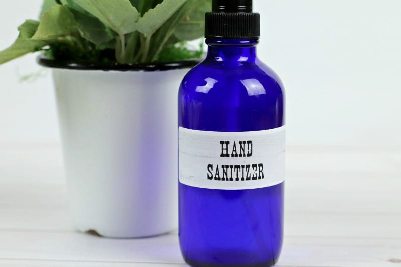 hand sanitizing spray near a plant in a white pot