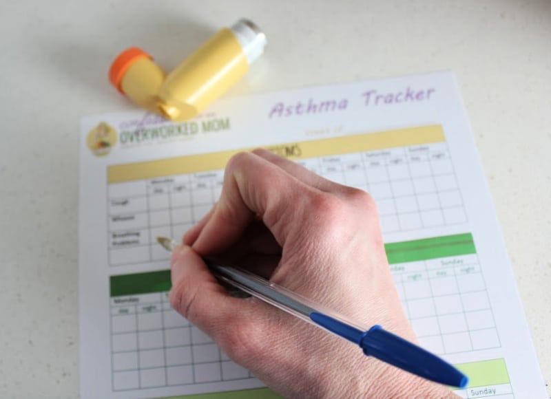 writing on an asthma tracker to monitor asthma symptoms