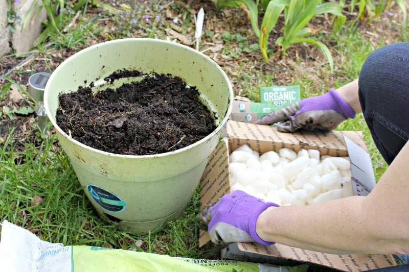 adding drainage material to a container garden