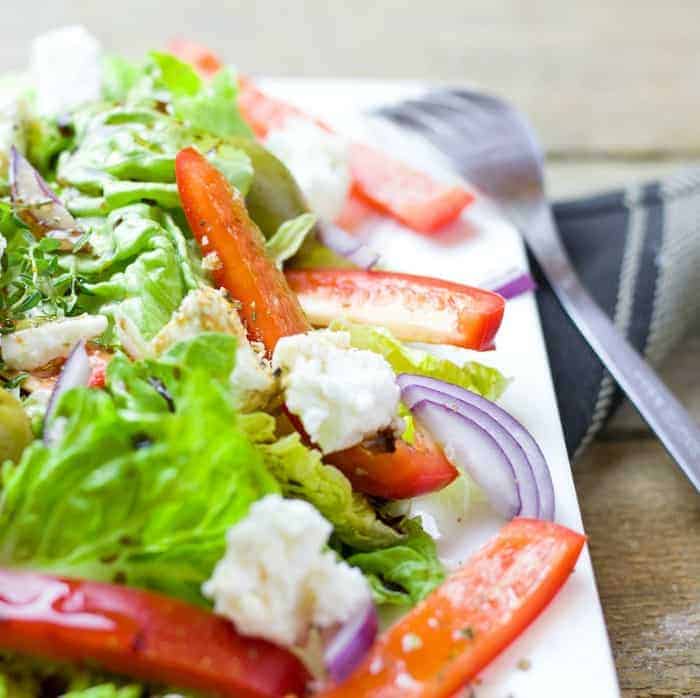 a greek salad on a white dish