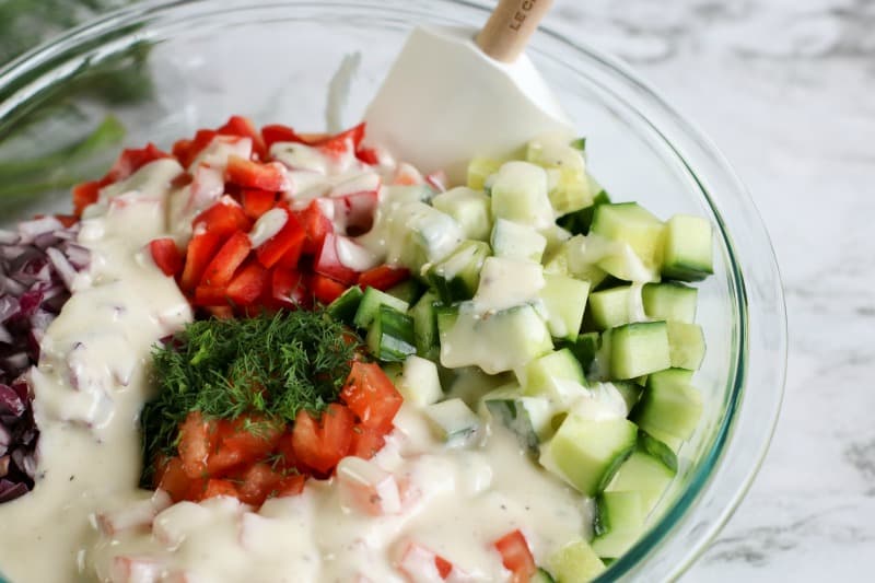 cucumbers, tomatoes, peppers, dill and mayonnaise in a bowl