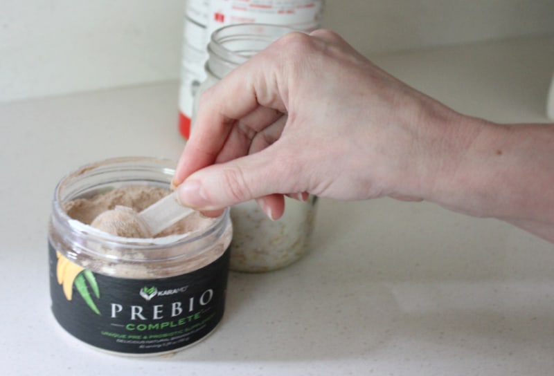 scooping out a prebiotic powder from the container
