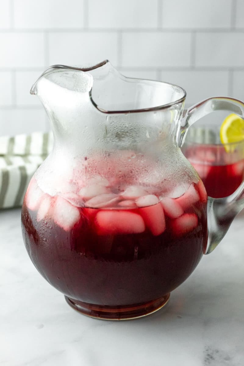 a pitcher of herbal tea that is brightly colored with ice