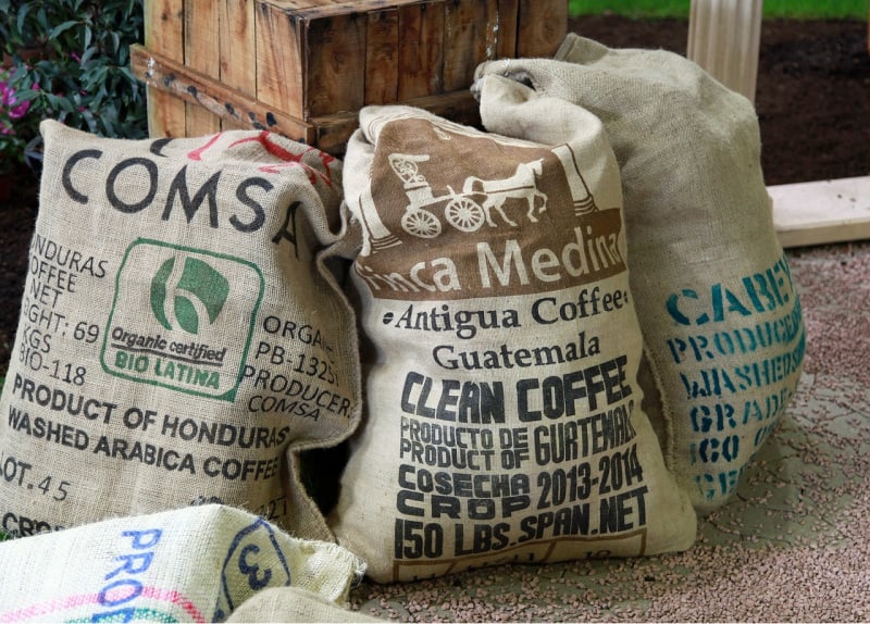 burlap bags full of beans near a wooden stand