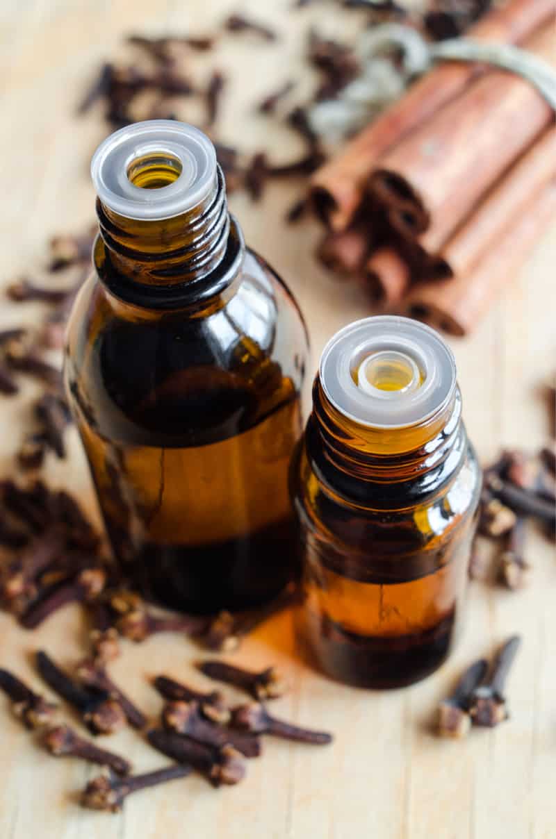 essential oil bottles near cloves and cinnamon