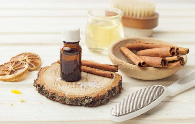 essential oil with cinnamon stick and a buffer for skincare