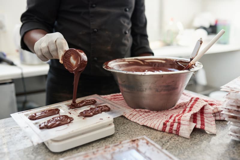 a person making chocolate candy