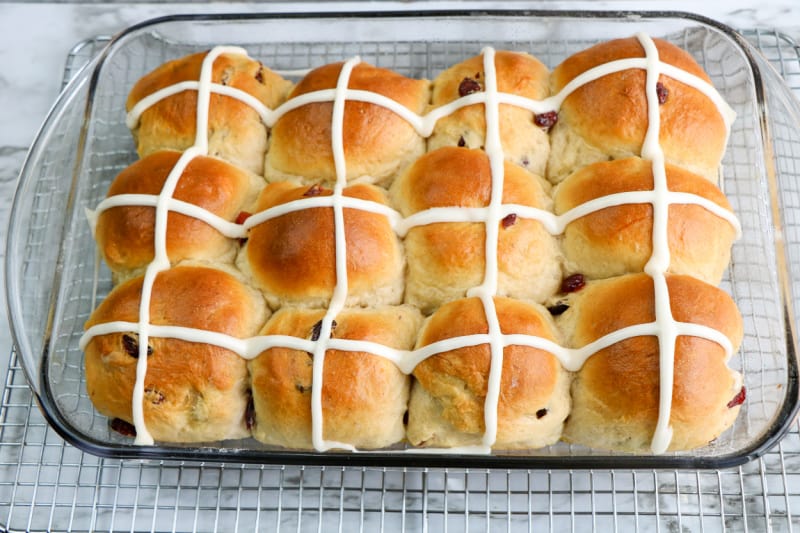 a pan full of hot crossed buns with icing