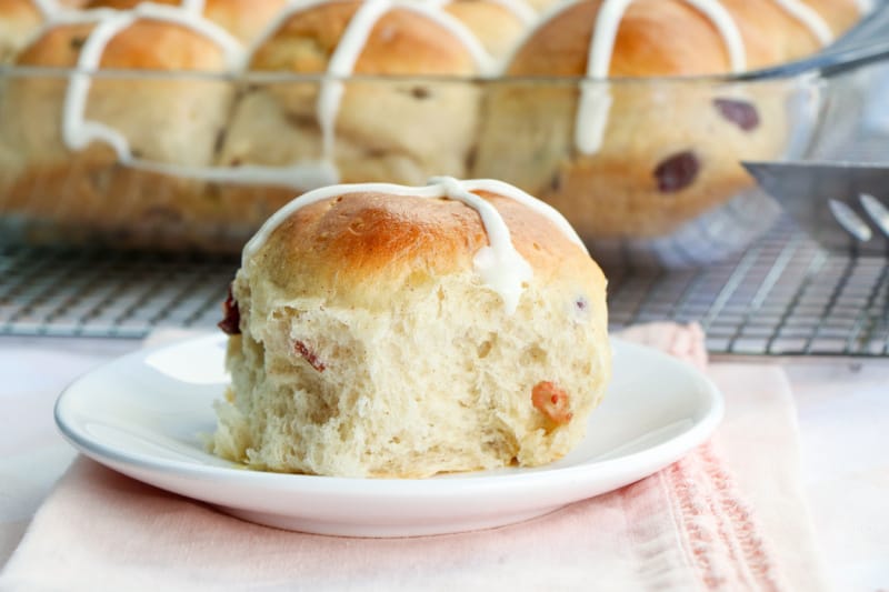 a yeast bread bun with currants on a plate