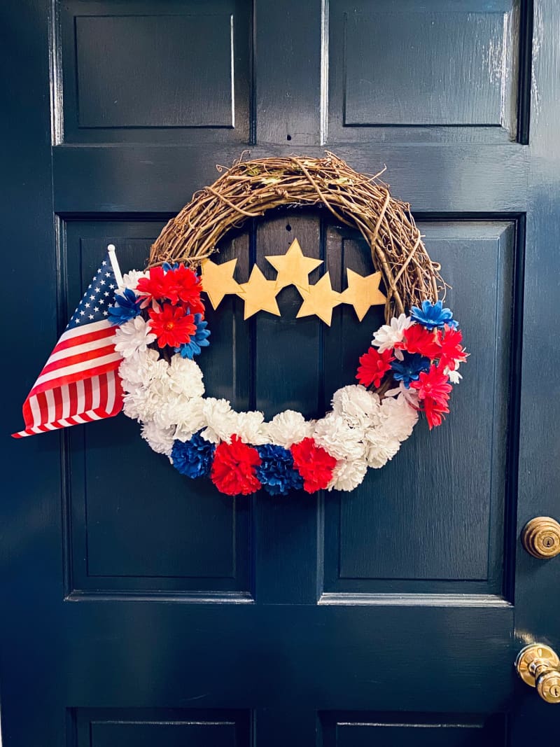 a red white and blue wreath on a blue door