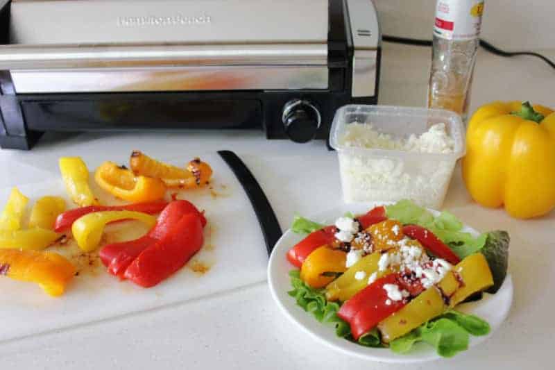 a plate of grilled peppers near feta cheese and a grill