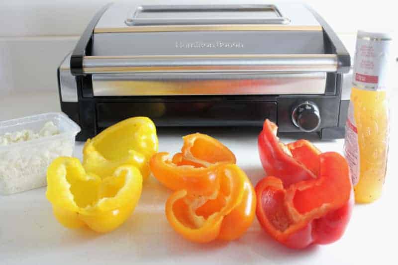 colorful peppers cut in half in front of a grill