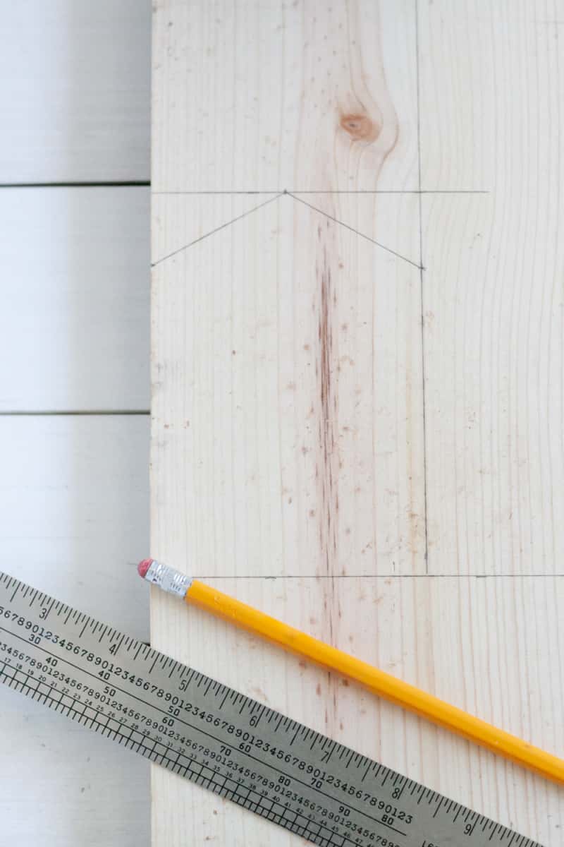 a piece of pine wood with a pencil and ruler