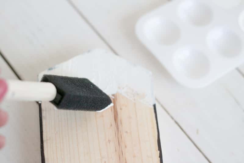 painting a wooden shape with white paint