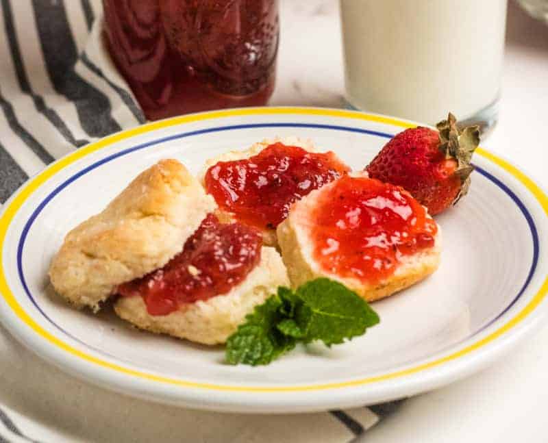 biscuits on a while plate with strawberry jam