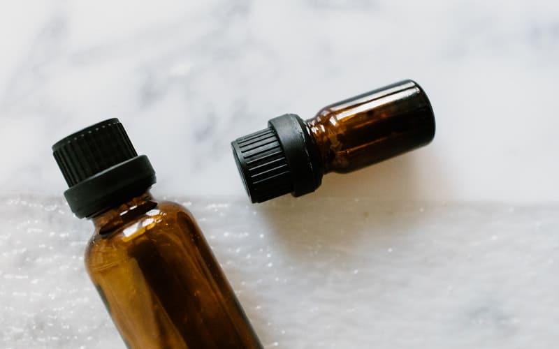 2 small brown essential oil bottles on a white background