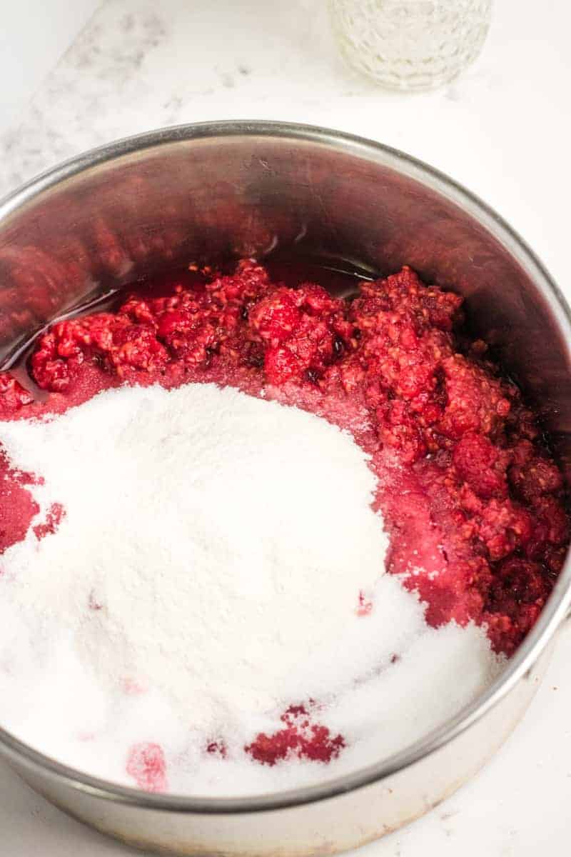 crushed raspberries in a pot with sugar and pectin