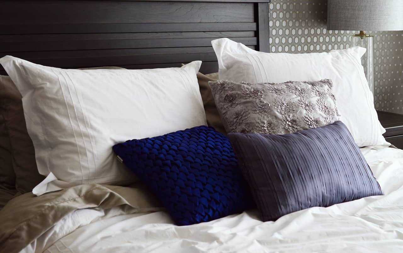 blue and white pillows on a bed