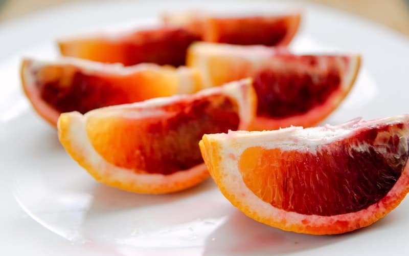 sliced blood oranges on a white plate