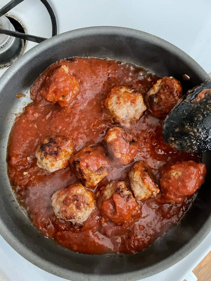 meatballs cooking in a pan on the stove