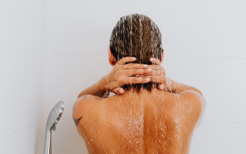 a woman showering with moisturizing products