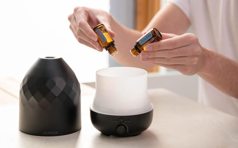 a woman adding oils to a diffuser