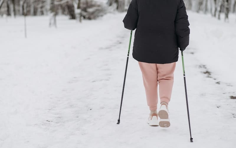 an elderly woman walking in the snow