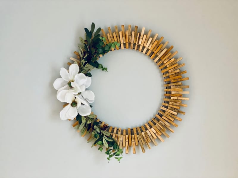 a magnolia clothespin wreath on the wall