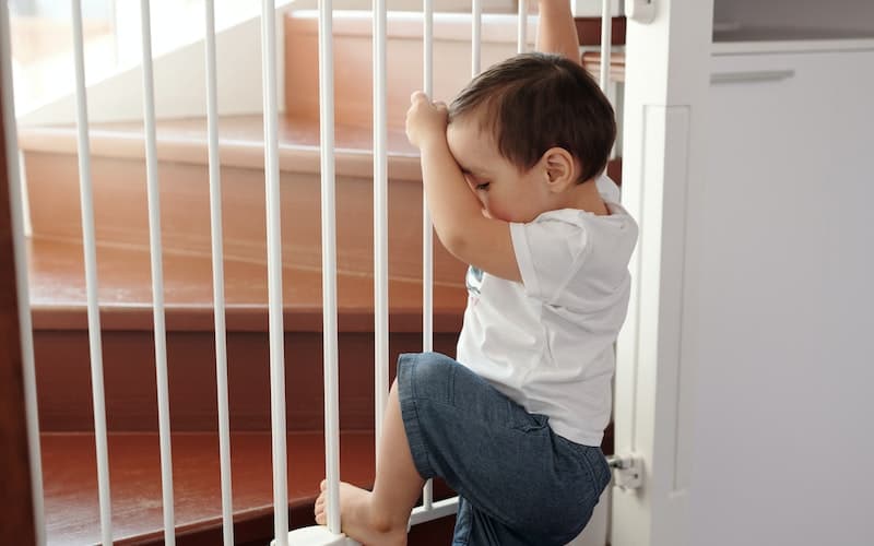 little boy near a child safety gate