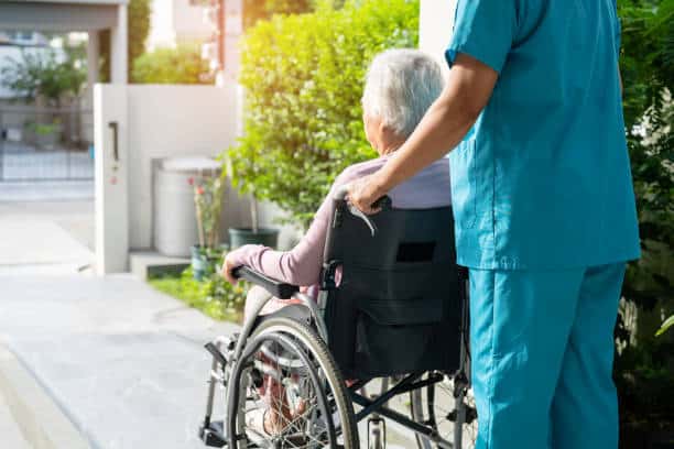 caregiver pushing a woman in a wheelchair