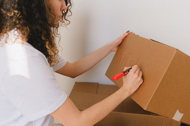 woman holding brown cardboard box